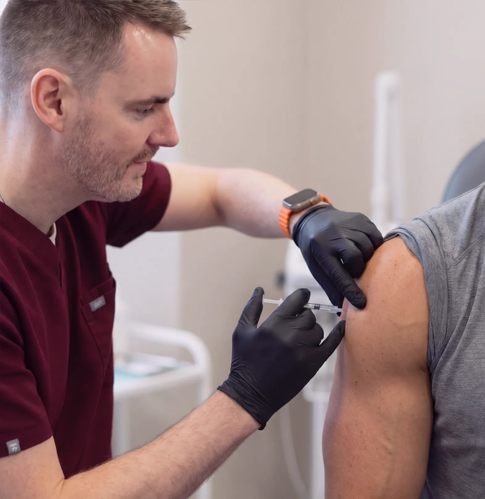 Adam injecting a male client with a vitamin booster