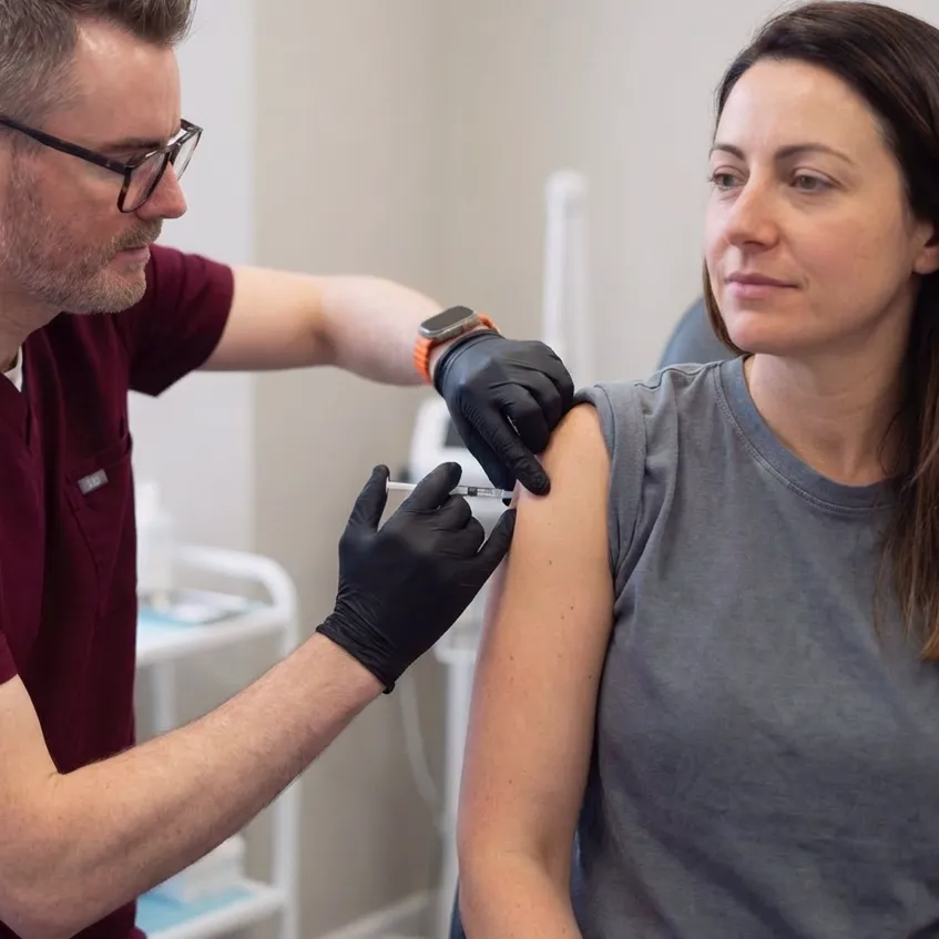 Adam injecting a female client with a vitamin booster